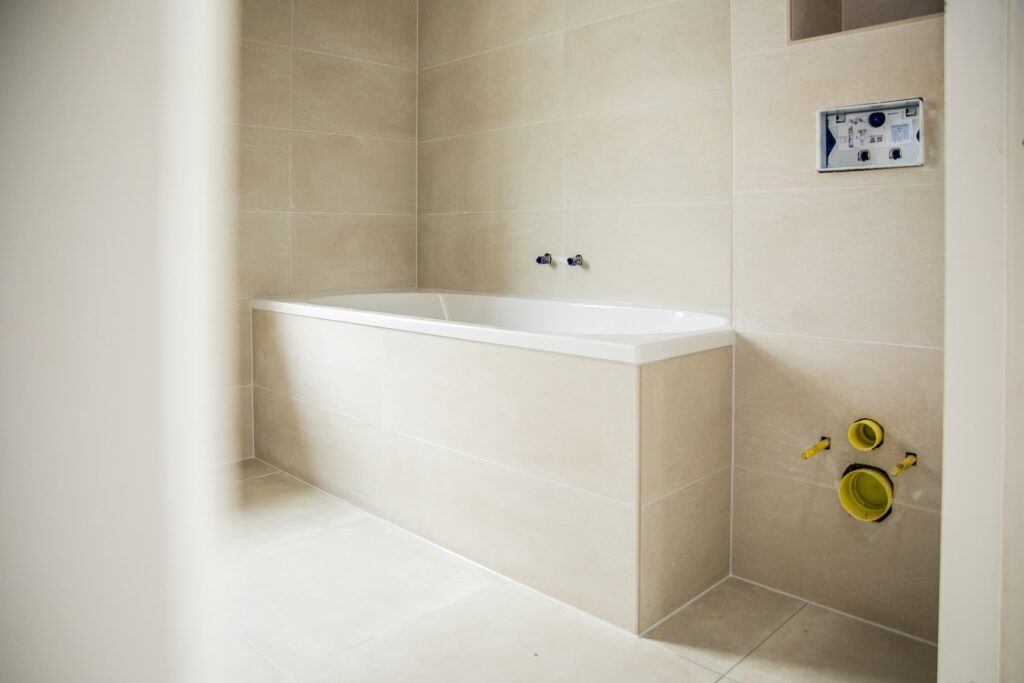 Lichte prefab badkamer met ingebouwd ligbad en beige tegels