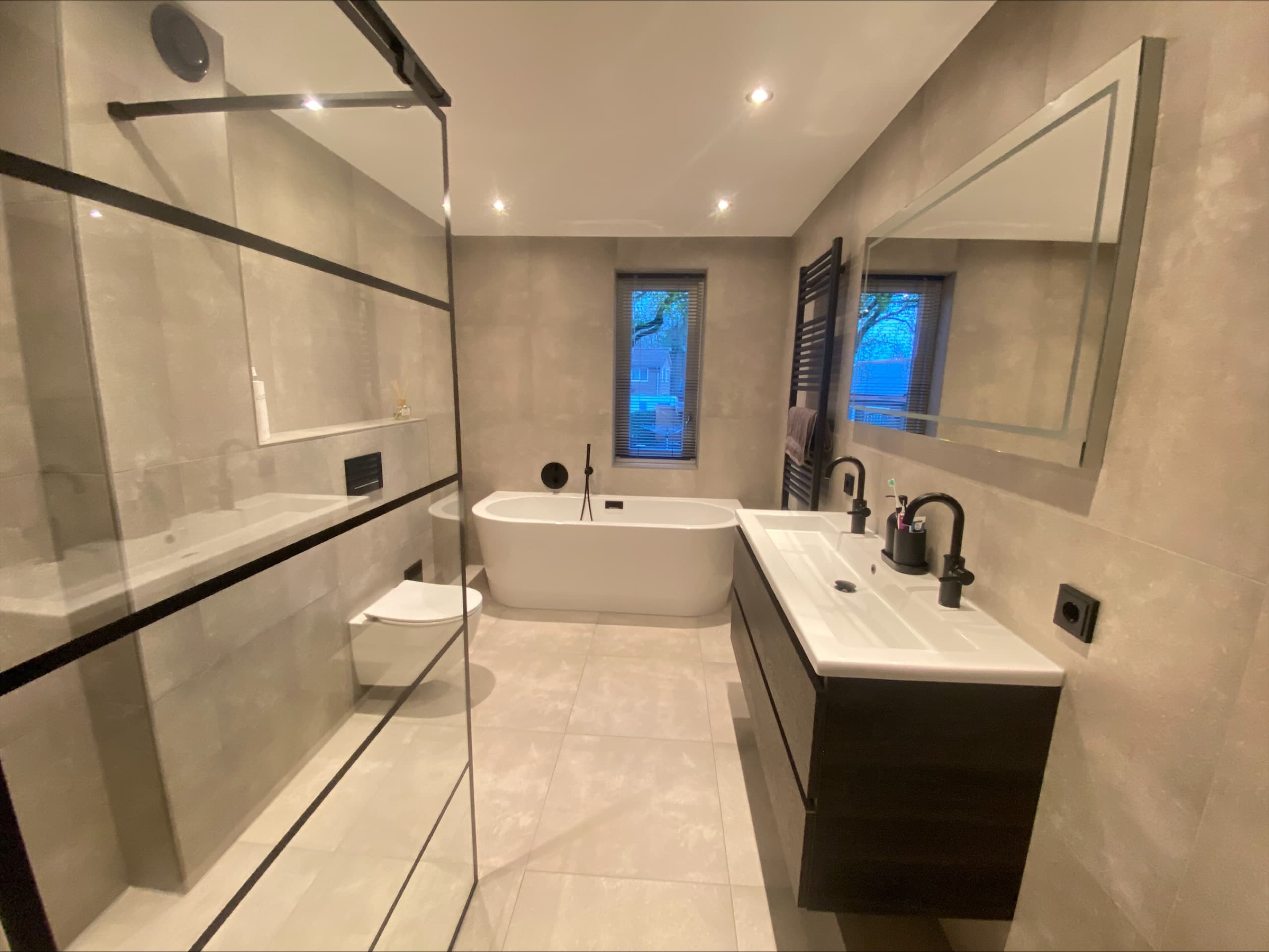 Moderne prefab badkamer met vrijstaand ligbad en walk-in douche door Juffers Badkamers
